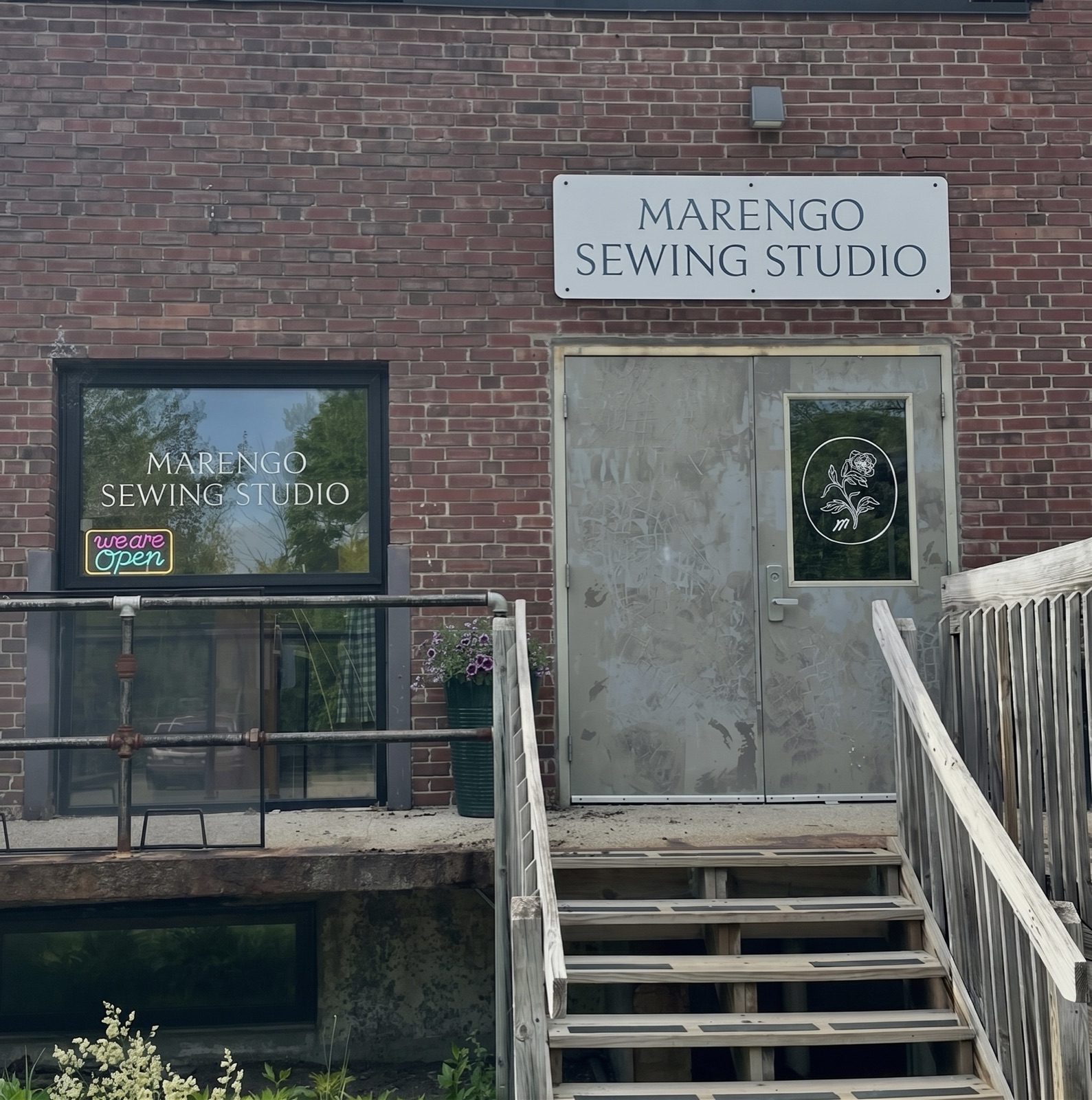 Marengo Sewing Studio storefront with sign and neon "we are open" light